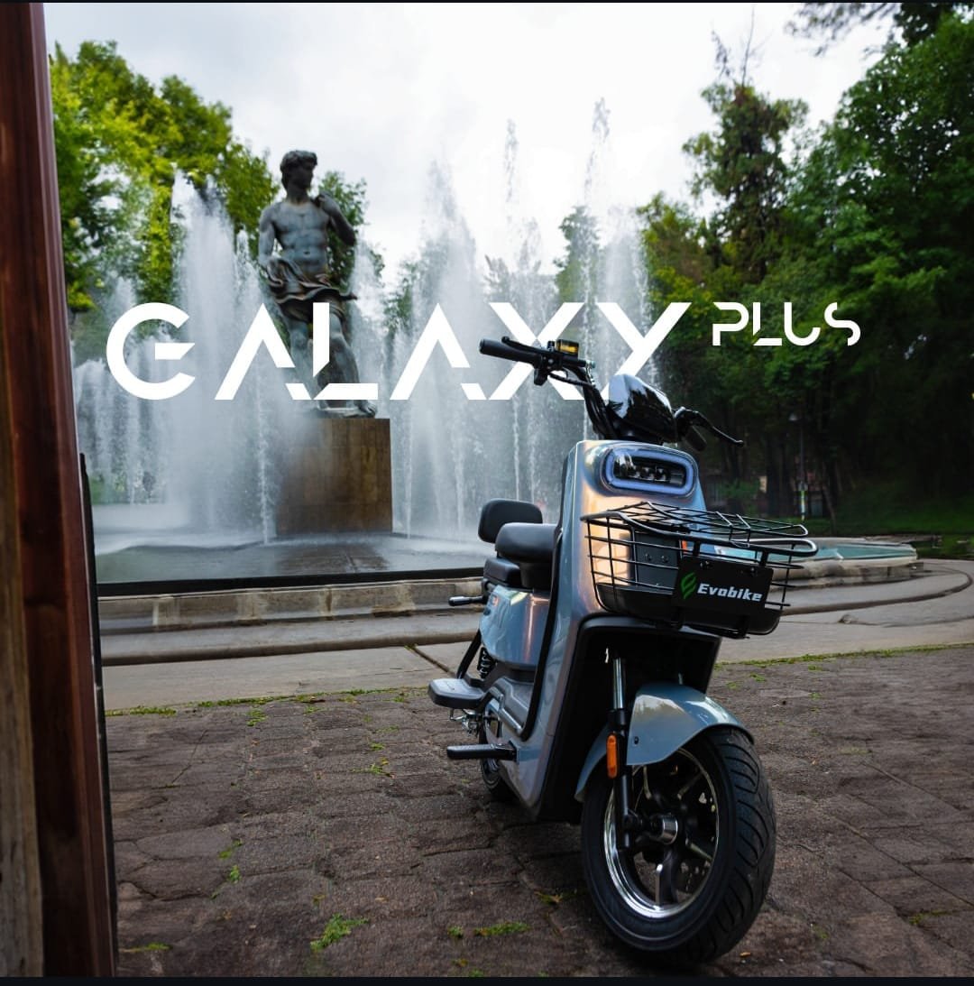 Bicicletas Eléctricas Evobike Galaxy Plus frente a fuente urbana con escultura central
