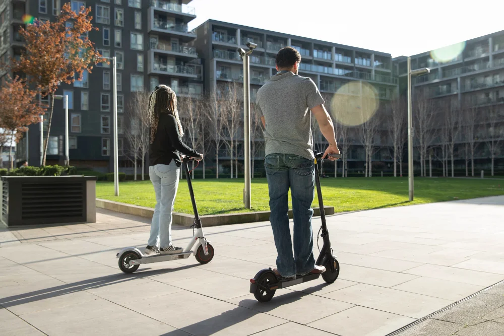 Pareja desplazándose en scooter eléctrica moderna para movilidad urbana sostenible