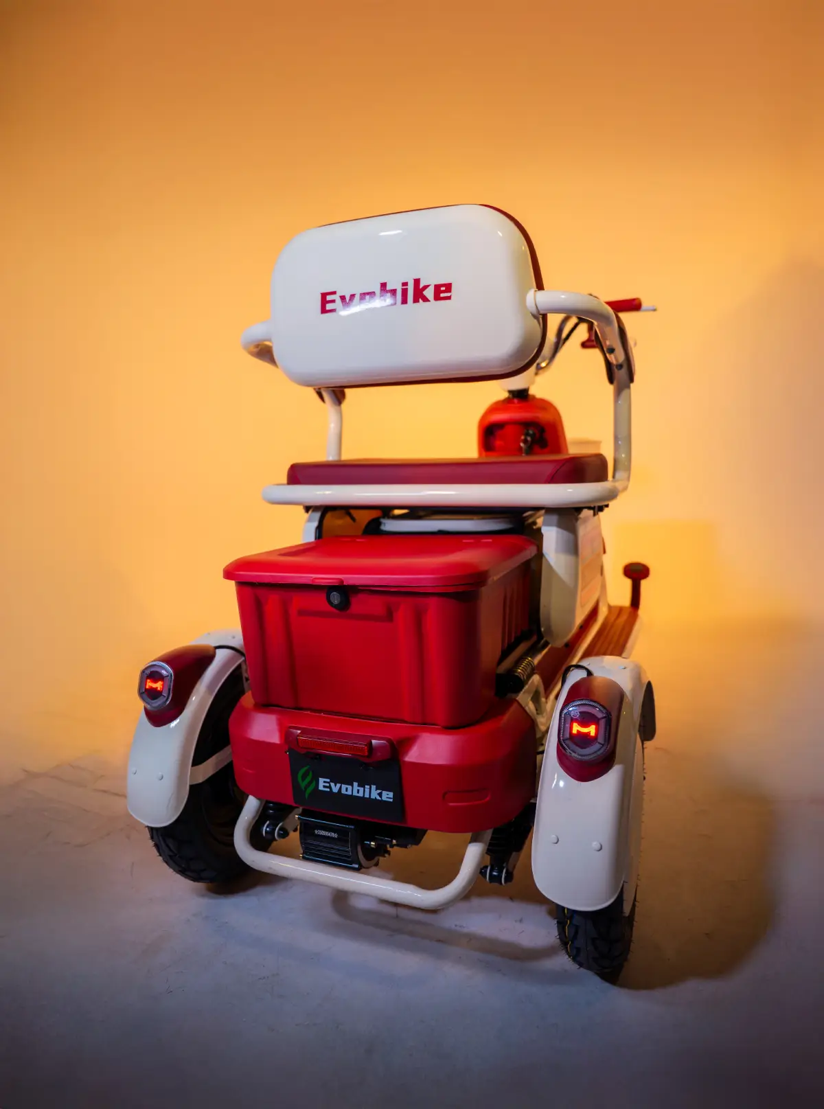 Triciclo eléctrico Family Q Evobike en color rojo y crema, con compartimento trasero y diseño urbano moderno.