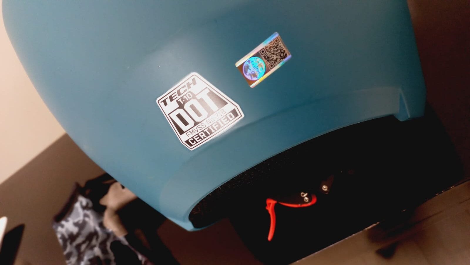 Detalle de certificación DOT en casco azul TECH T10, etiqueta visible.